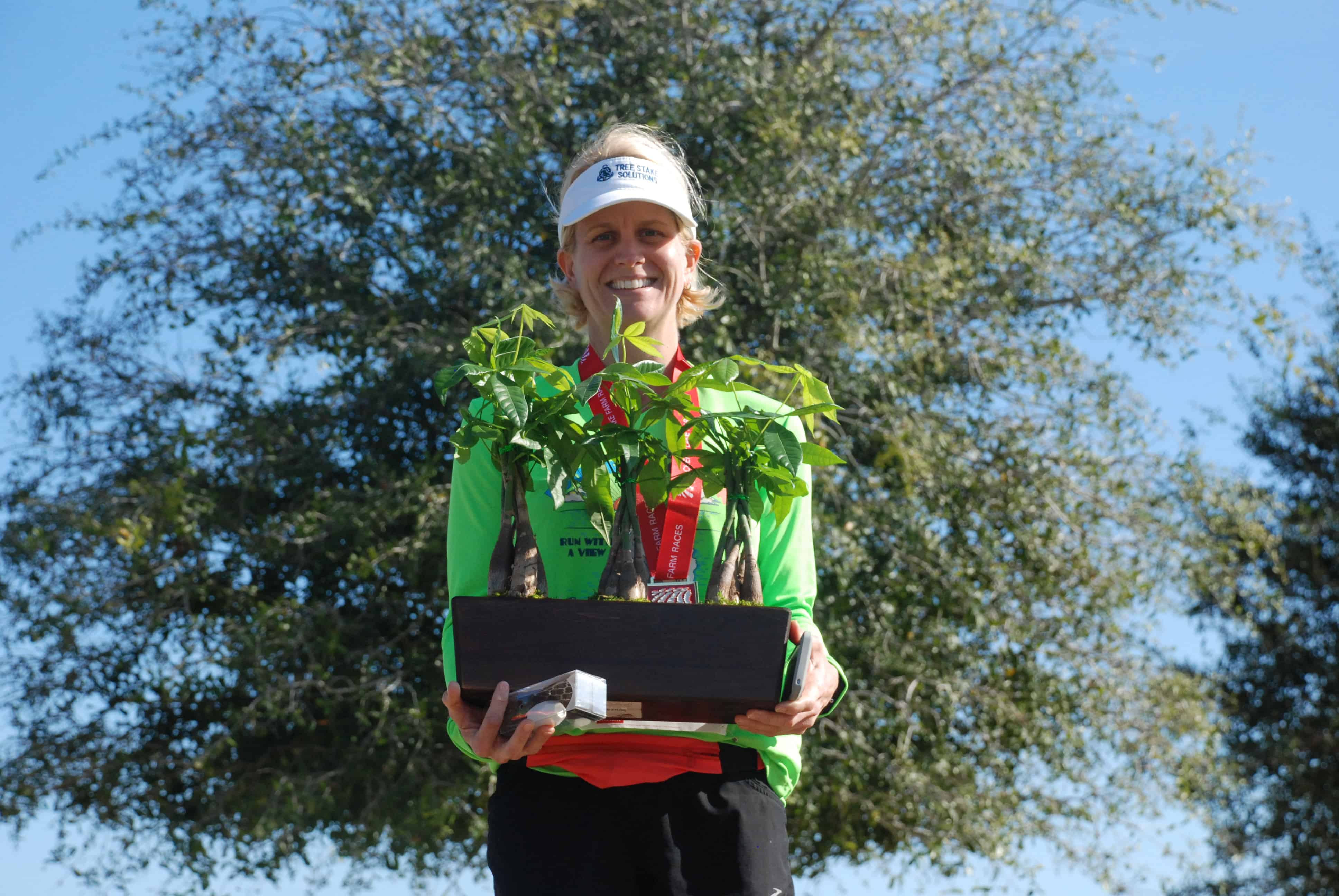 A happy female runner holds up her living LiveTrends prize.