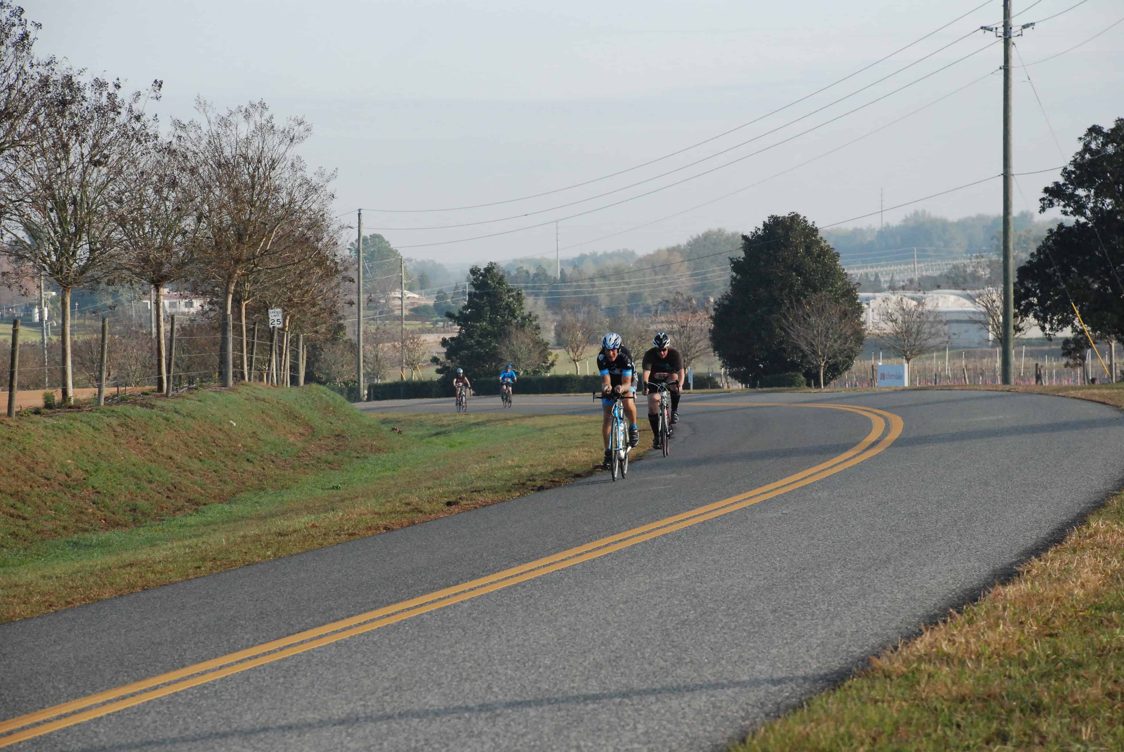 Cyclists round a bend of Cherry Lake Road.