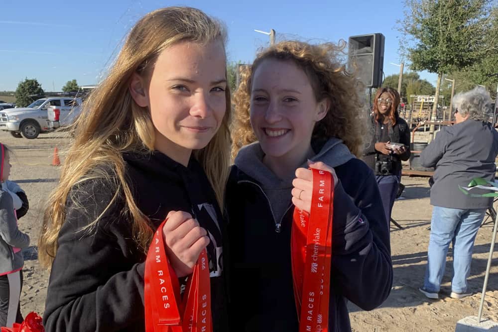 Teenagers of the Cherrylake Farm Races smile while holding up race medals.